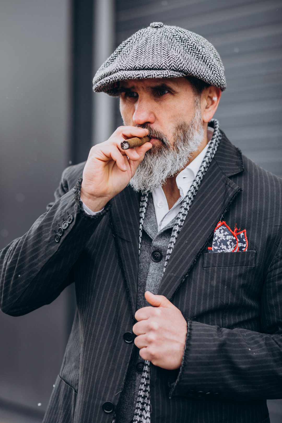 uomo che fuma un sigaro in giacca e fazzoletto da taschino