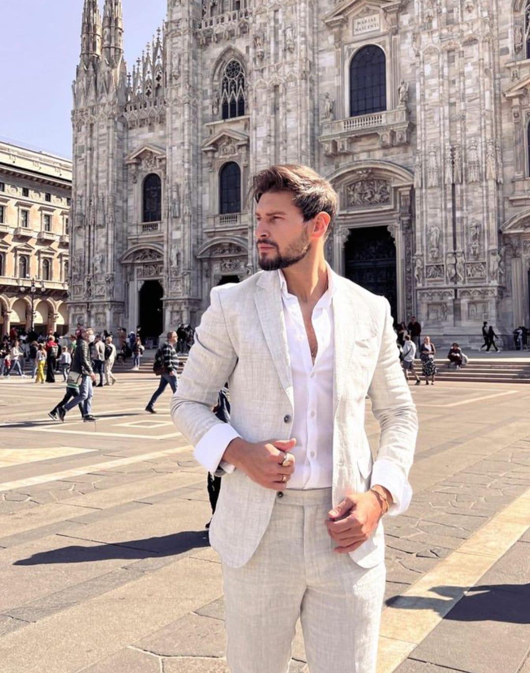 Modelli in abiti sartoriali e cravatte in una scena di moda maschile ambientata a Milano.